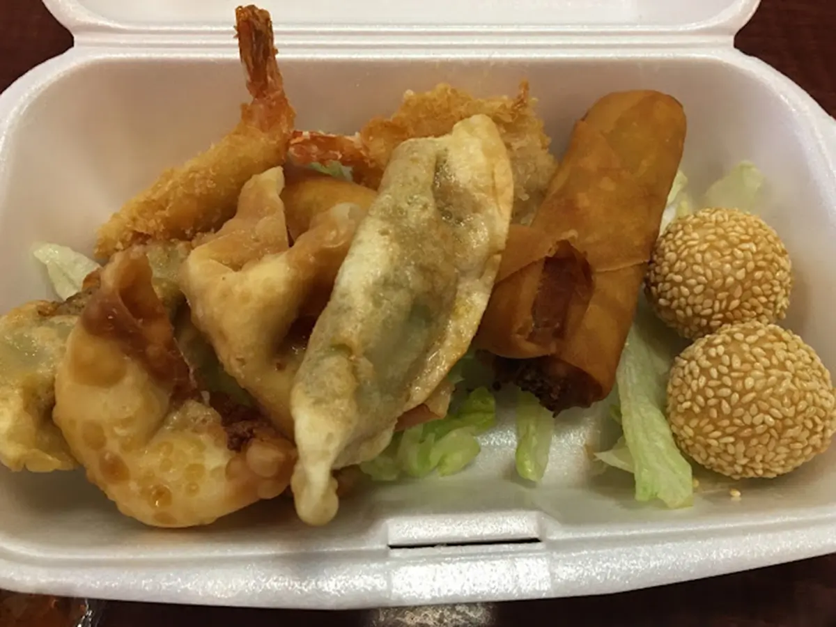 Appetizer sampler with egg roll, crab rangoon, chicken dumplings and sesame balls